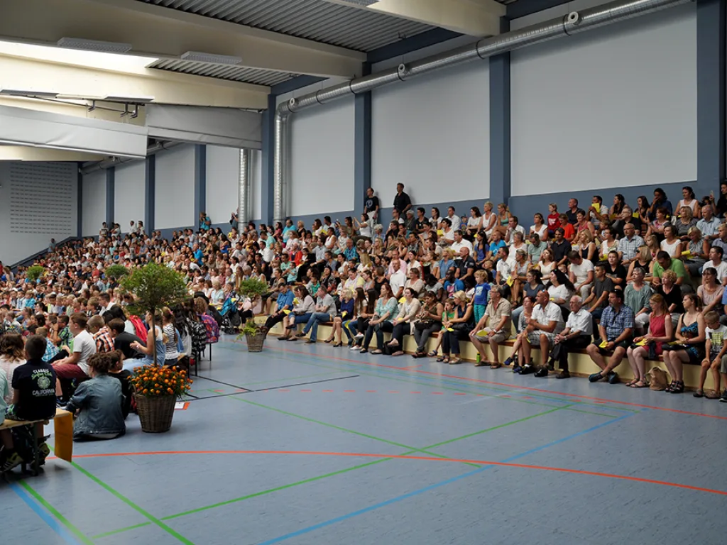 Blick über die sitzenden Kinder und Gäste in der Sporthalle.